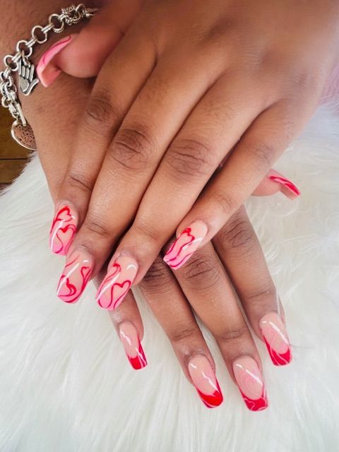 A close up of a woman 's nails with a red french manicure