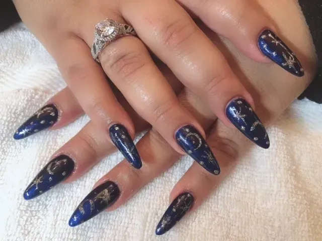 A close up of a woman 's nails with a ring on her finger