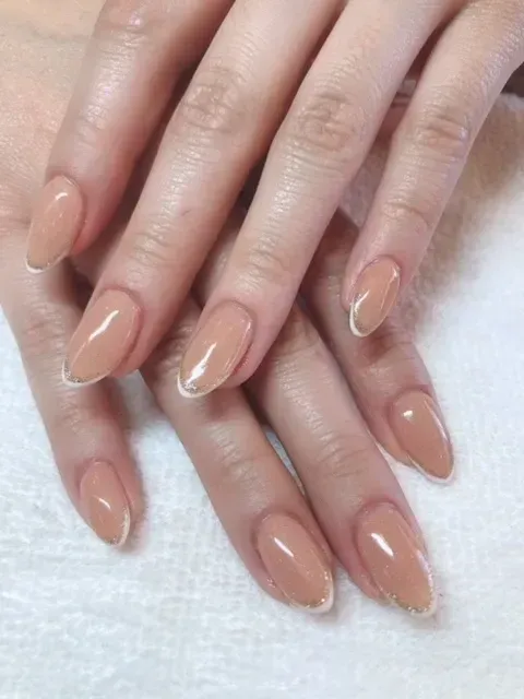A close up of a woman 's nails with a french manicure