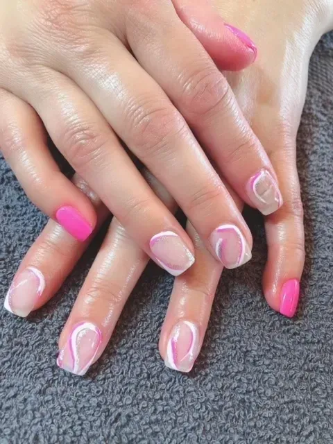 A close up of a woman 's hands with pink and white nails