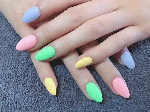 A close up of a woman 's nails with different colors