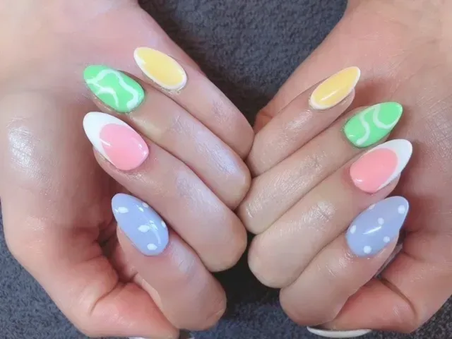 A close up of a person 's hands with colorful nails