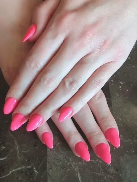 A close up of a woman 's hands with pink nails