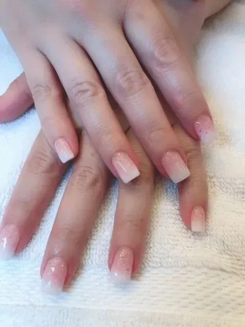 A close up of a woman 's nails on a white towel