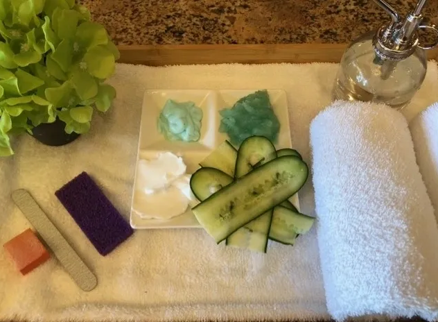 A white towel is sitting on a counter next to a plate of cucumber slices.