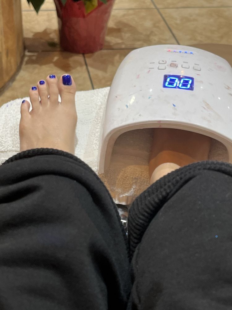 A woman 's foot is sitting on a towel next to a device that says enq