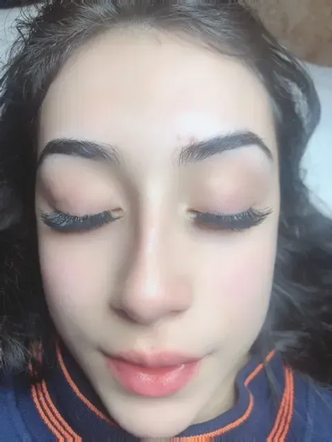 A close up of a woman 's face with her eyes closed.