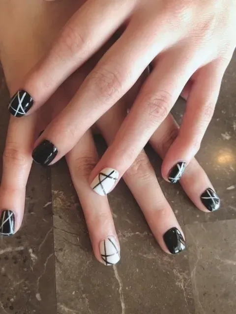 A close up of a woman 's nails with black and white designs