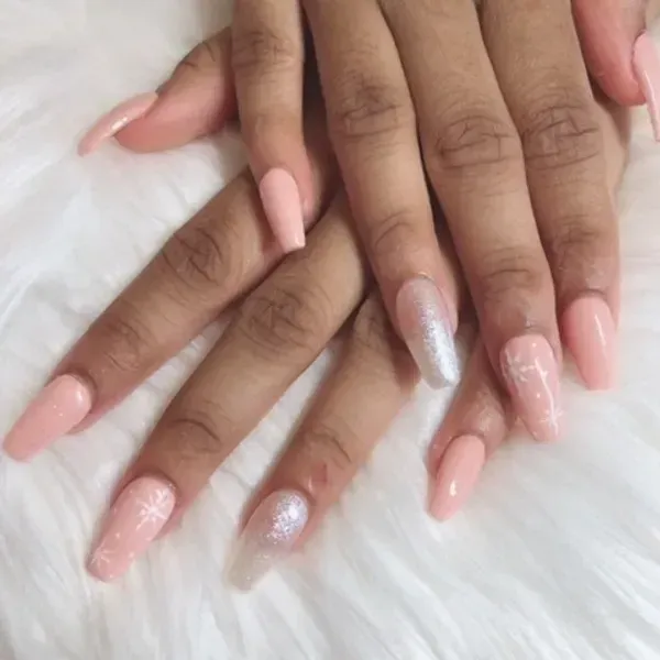 A close up of a woman 's nails on a white blanket.