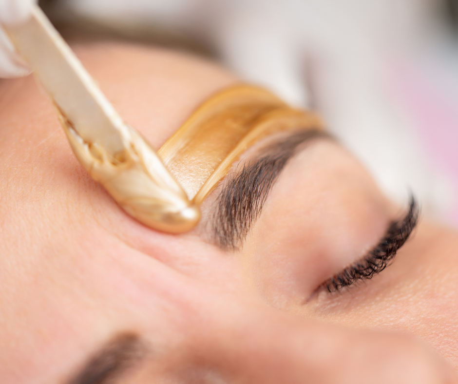A woman is getting her eyebrows waxed in a beauty salon.