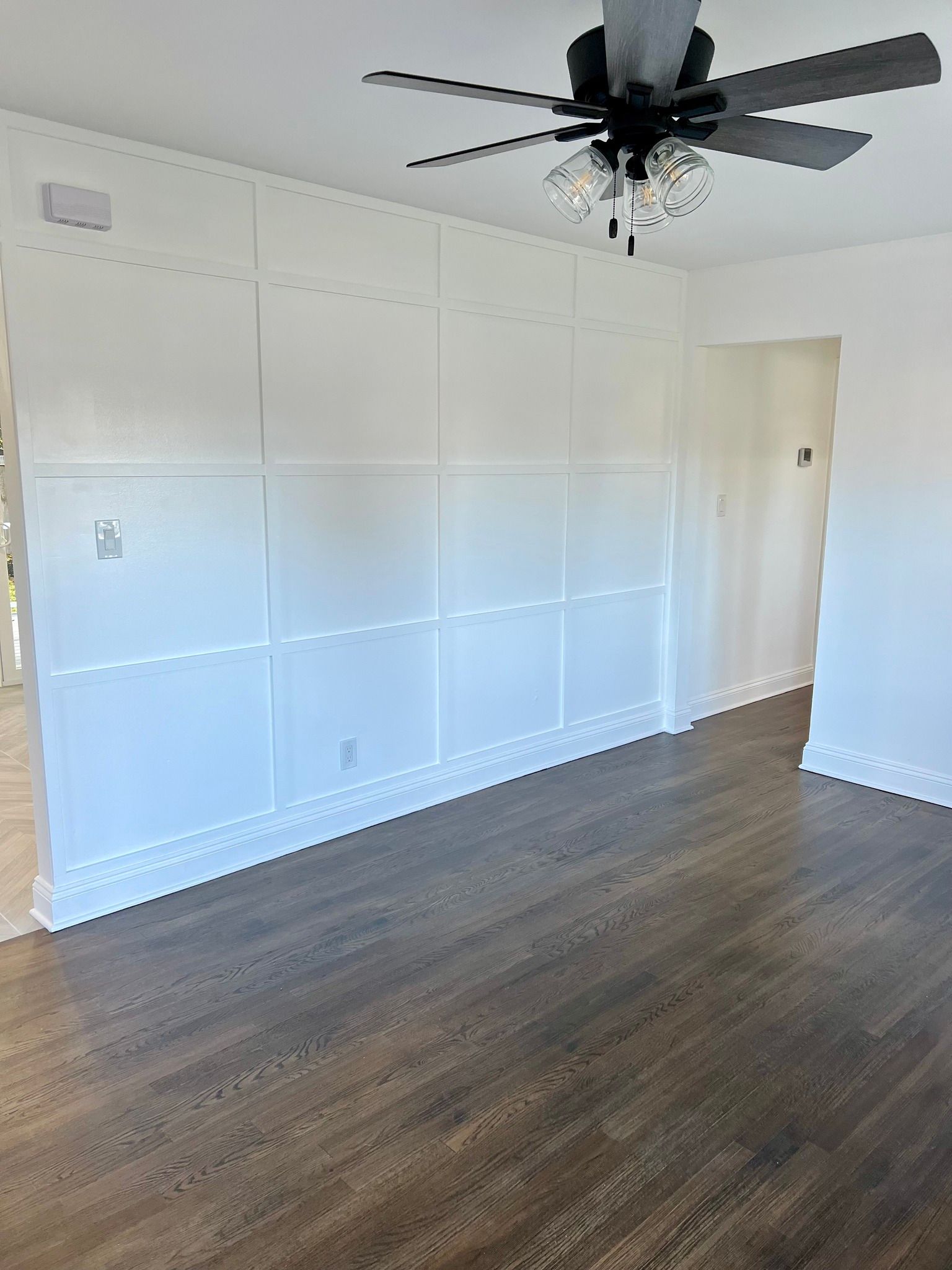 There is a ceiling fan in the corner of the room.