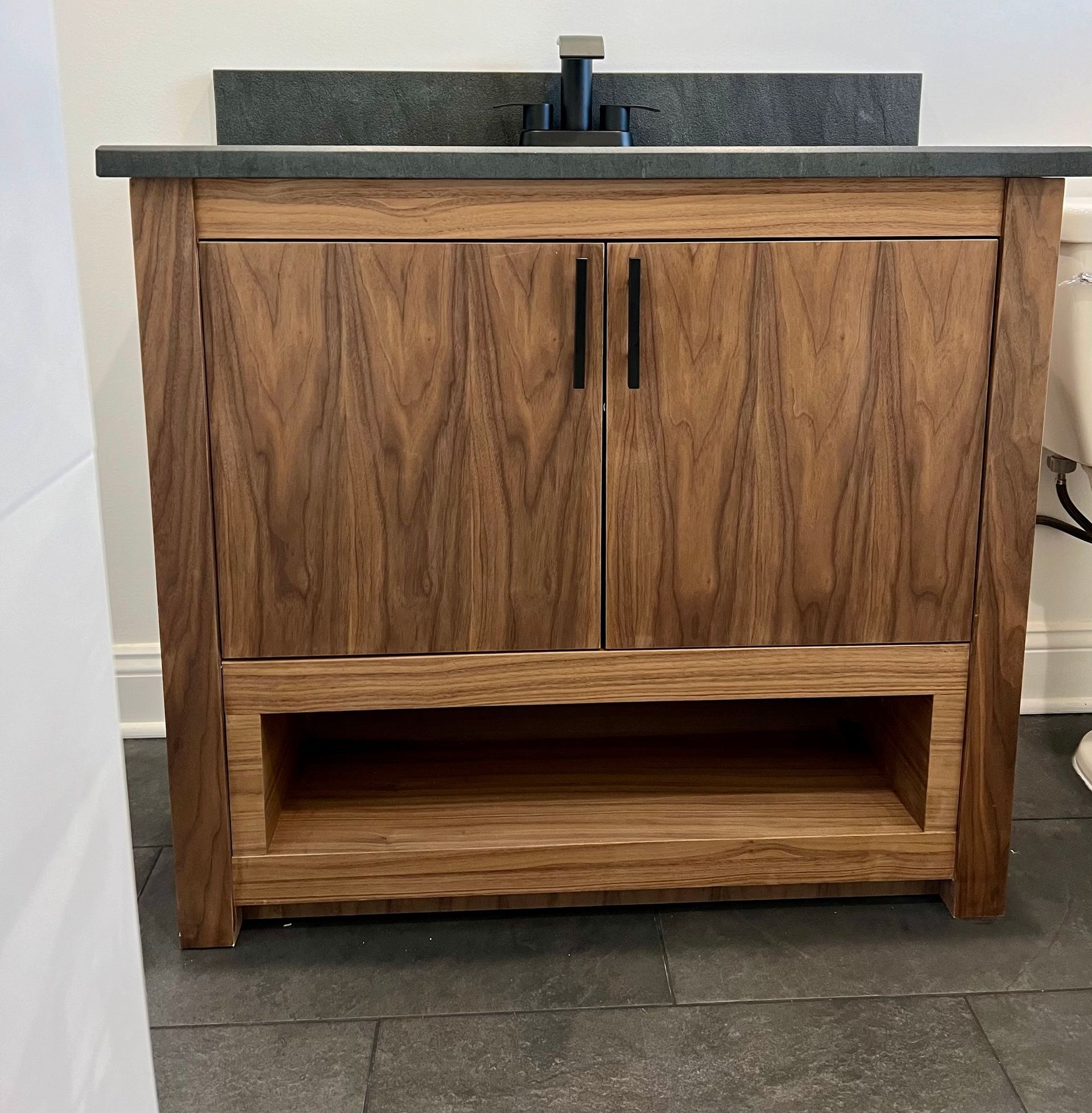 A bathroom vanity with a sink and a shelf underneath it
