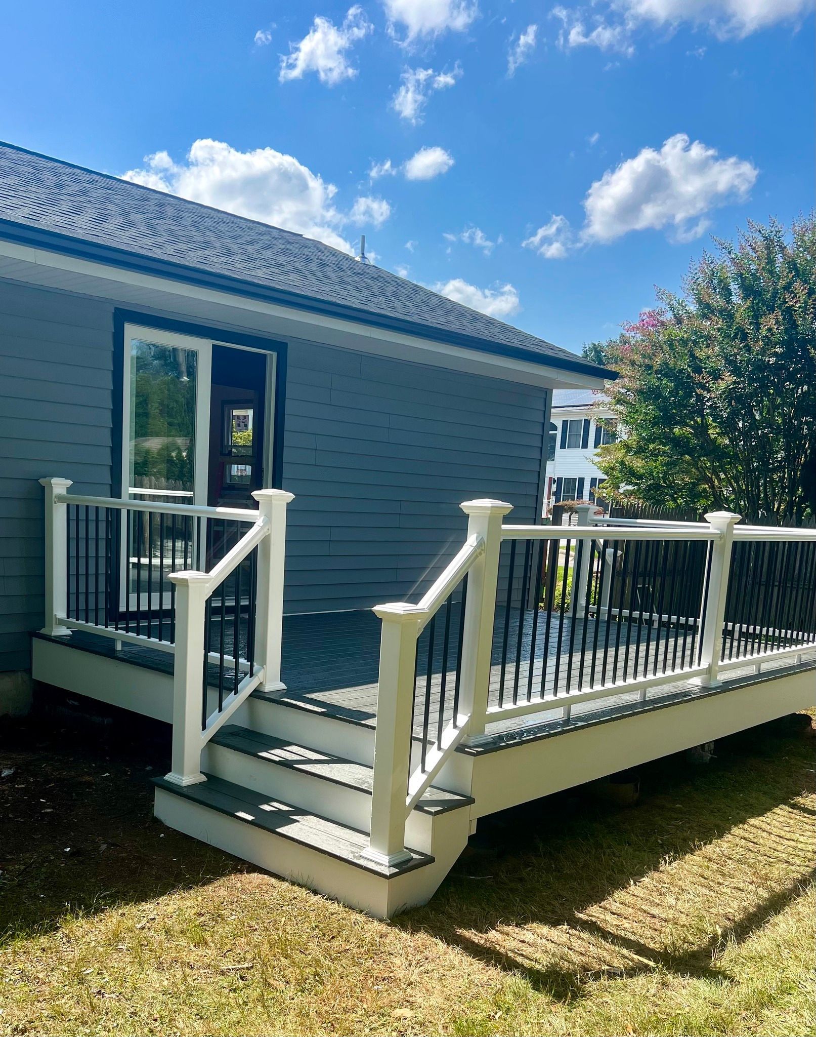 A small house with a deck and stairs in front of it.
