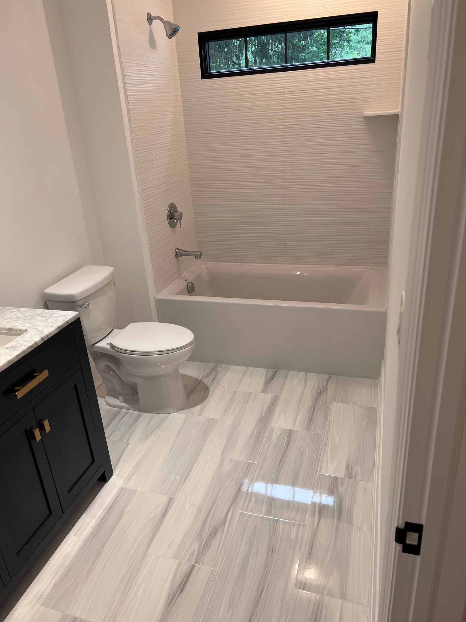 A bathroom with a toilet , sink , tub and shower.