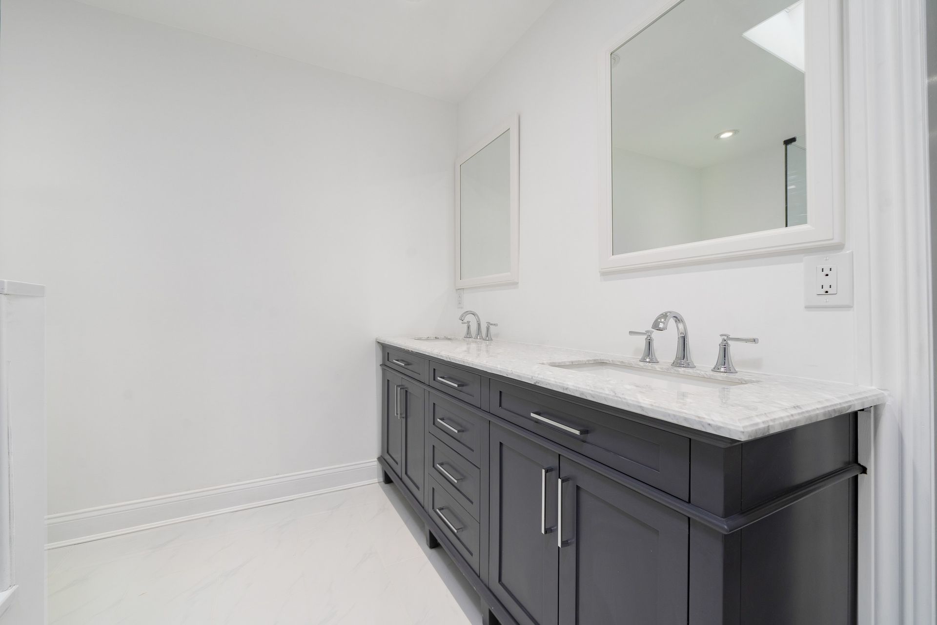 A bathroom with two sinks and a mirror.