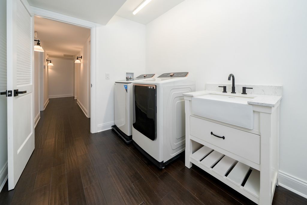A laundry room with a washer and dryer and a sink.