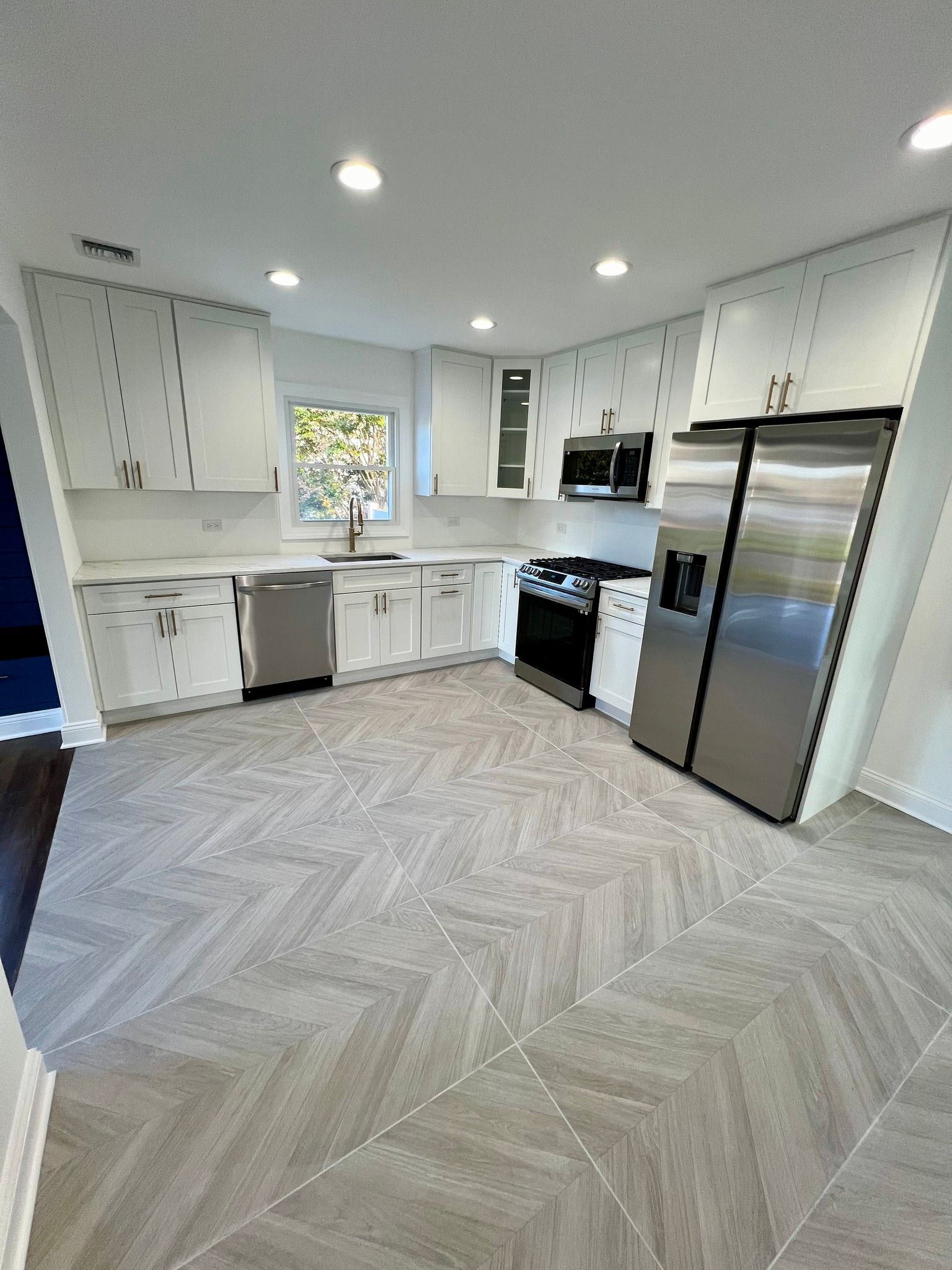 A kitchen with stainless steel appliances and white cabinets.