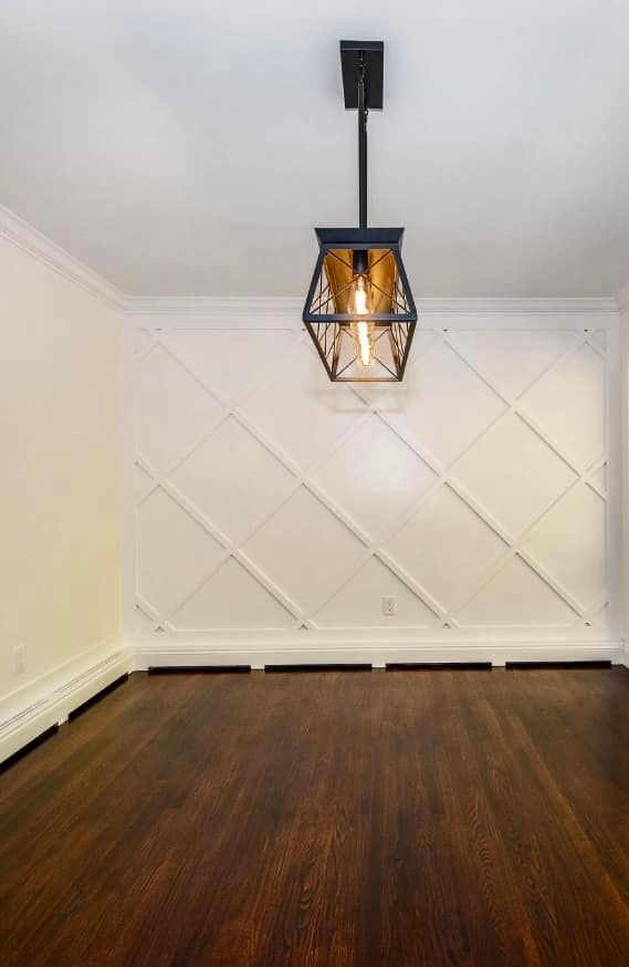 An empty room with a light fixture hanging from the ceiling.