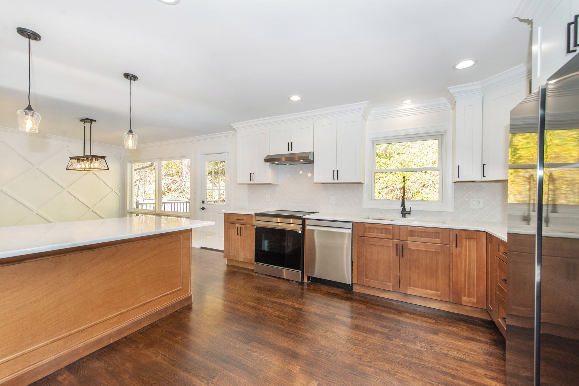 A kitchen with wooden cabinets , stainless steel appliances , and a large island.