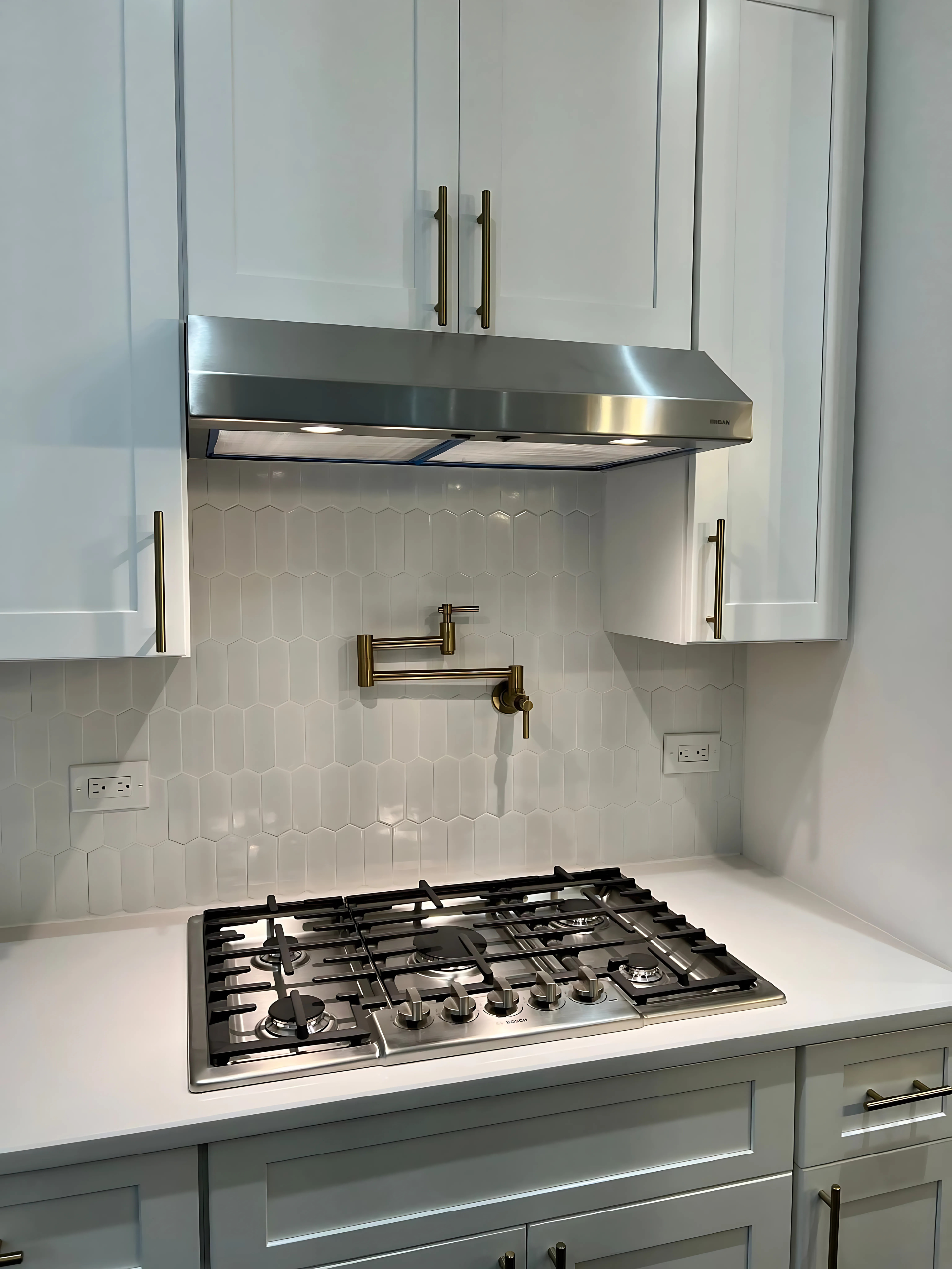 An empty kitchen with wooden cabinets and a black refrigerator