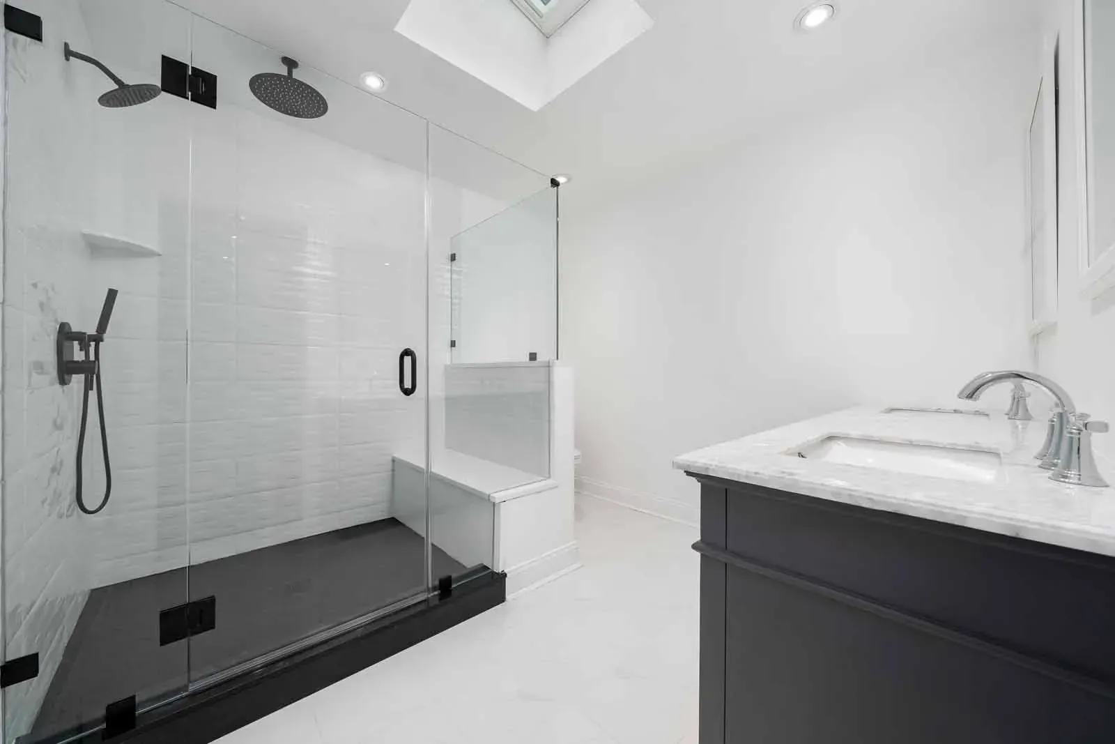 A bathroom with a walk in shower and a sink.