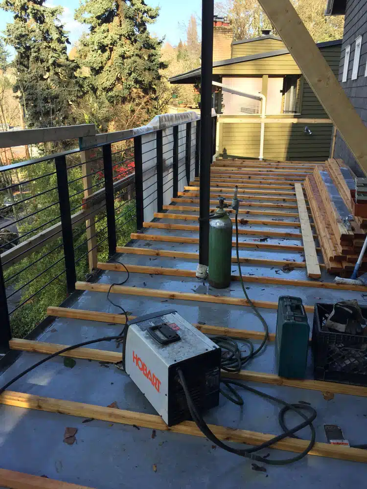 A welding machine is sitting on top of a wooden deck.