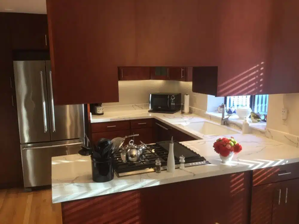 A kitchen with stainless steel appliances and red cabinets