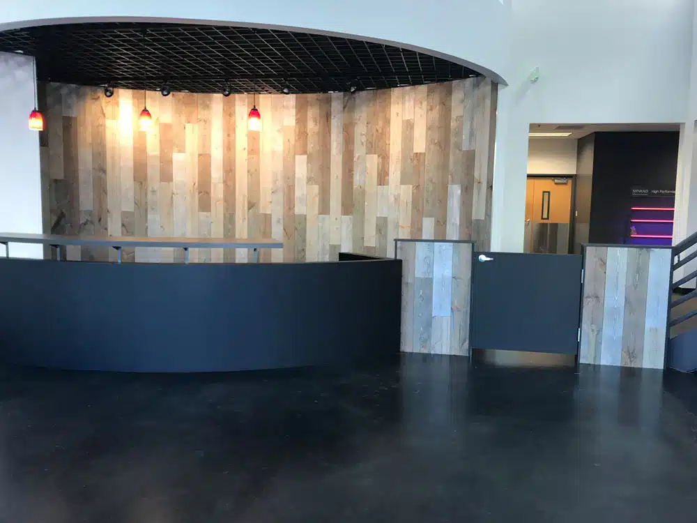 A large empty room with a wooden wall and a black counter.
