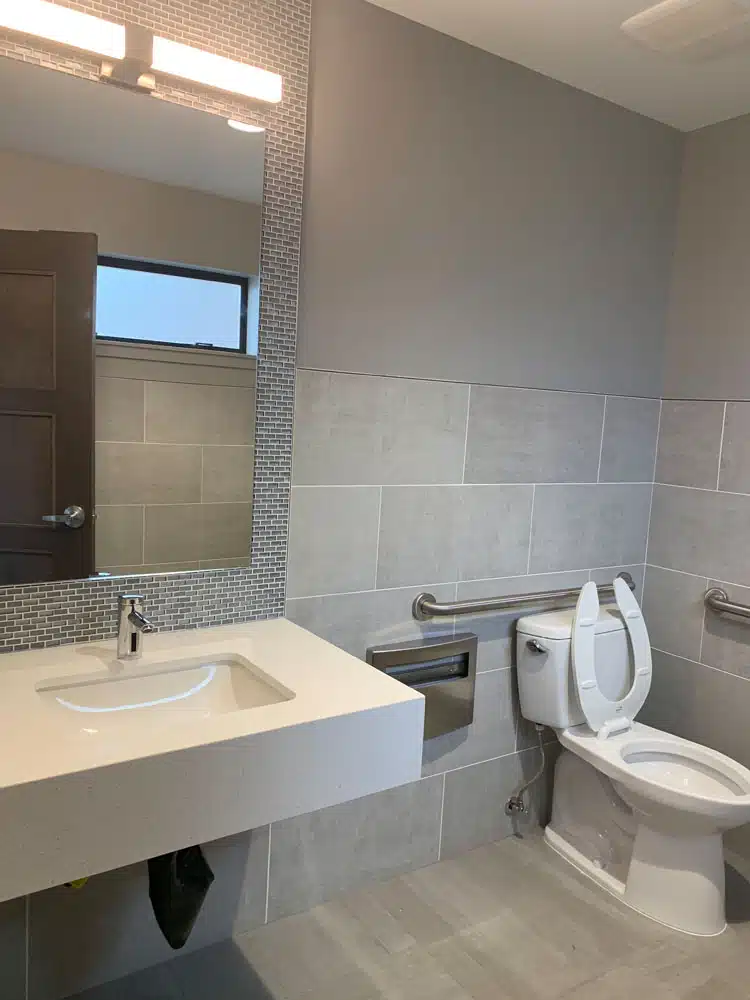 A bathroom with a sink , toilet and mirror.