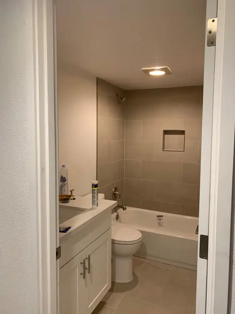 A bathroom with a toilet , sink , bathtub and mirror.