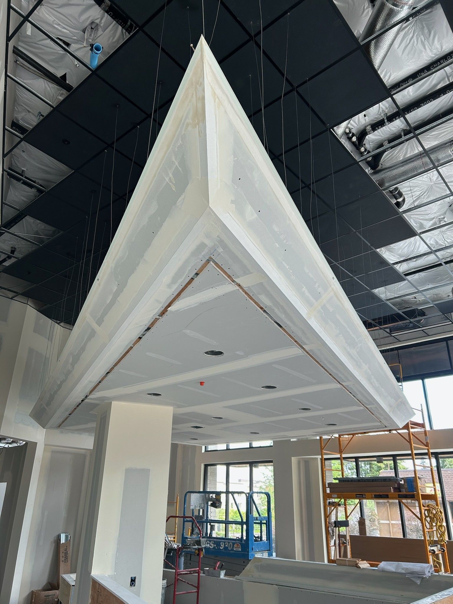 A triangle shaped ceiling is being built in a building.
