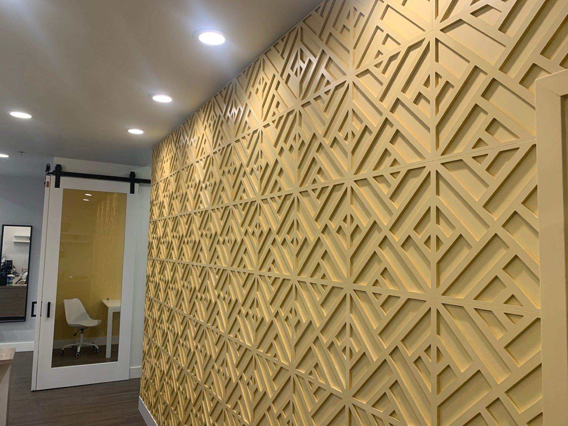 A hallway with a geometric pattern on the wall.