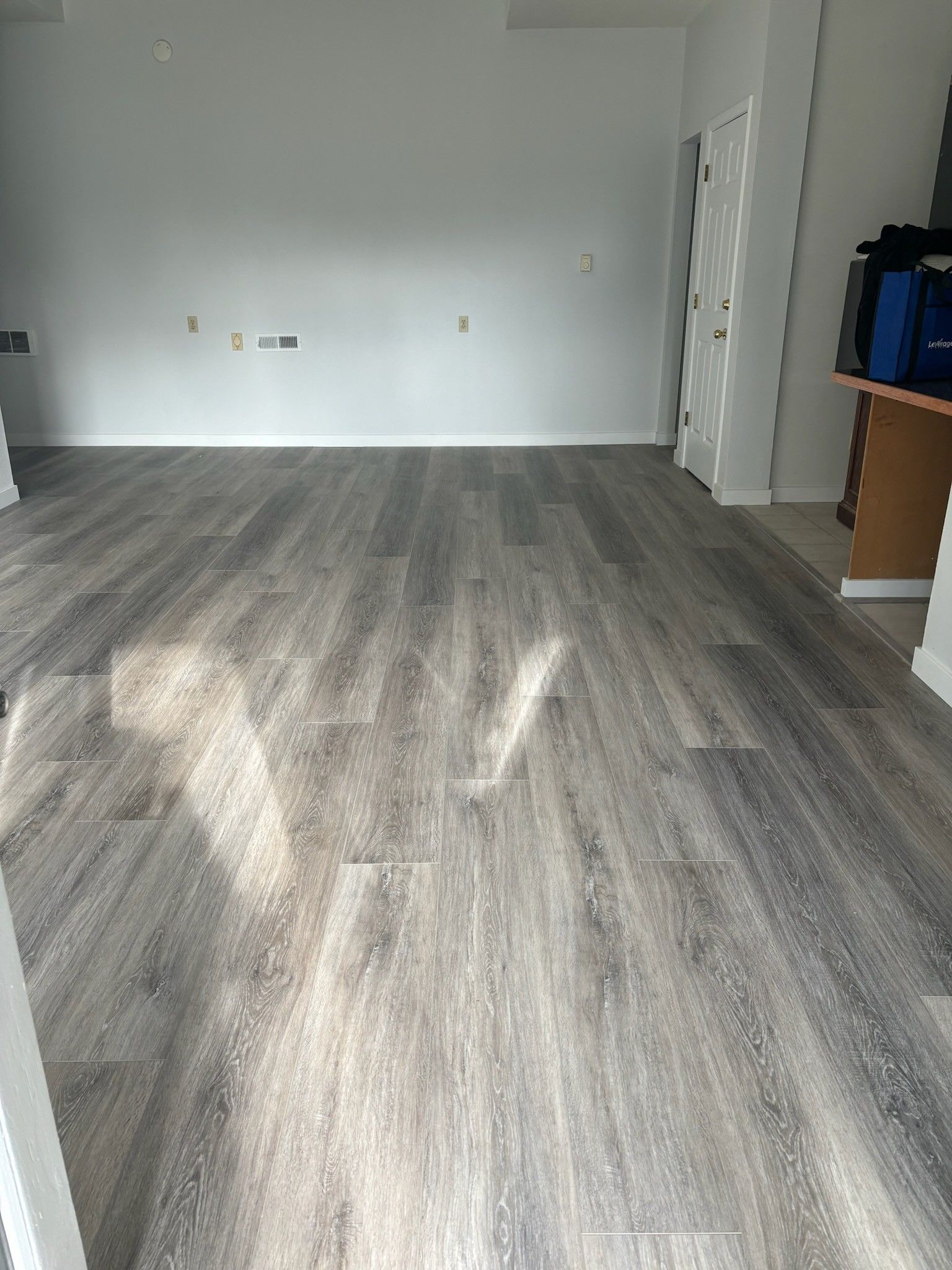 A living room with a wooden floor and white walls.
