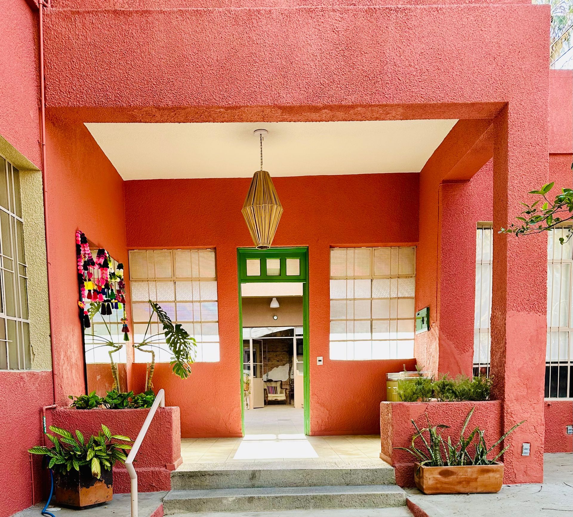 Un edificio rojo con una puerta y ventanas verdes
