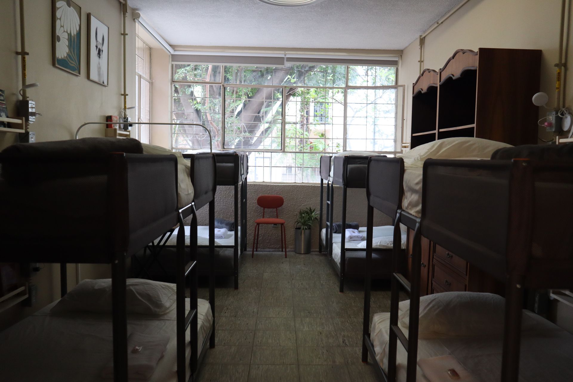 Una habitación llena de literas y una silla roja