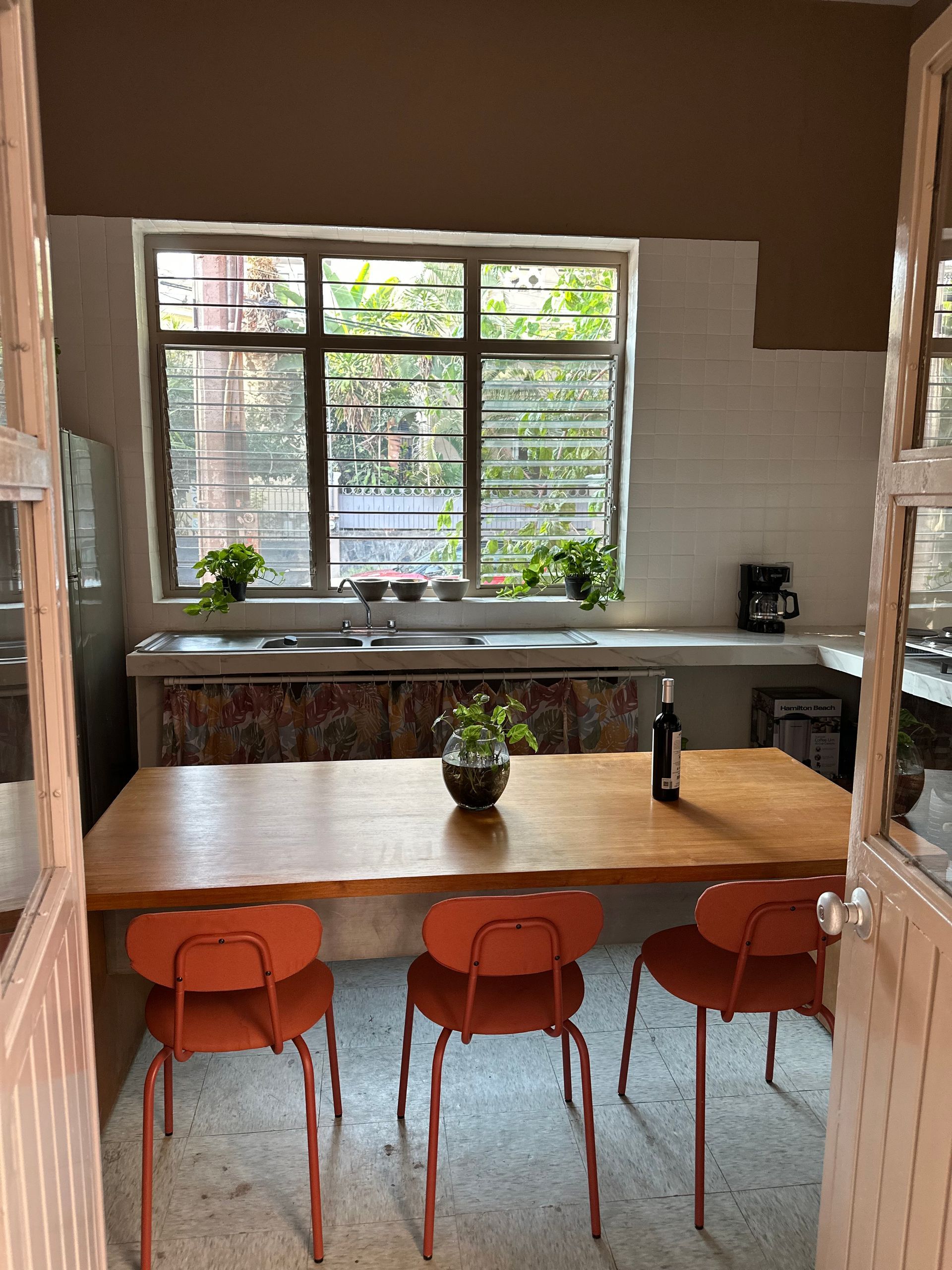 Una cocina con mesa y sillas y una ventana.