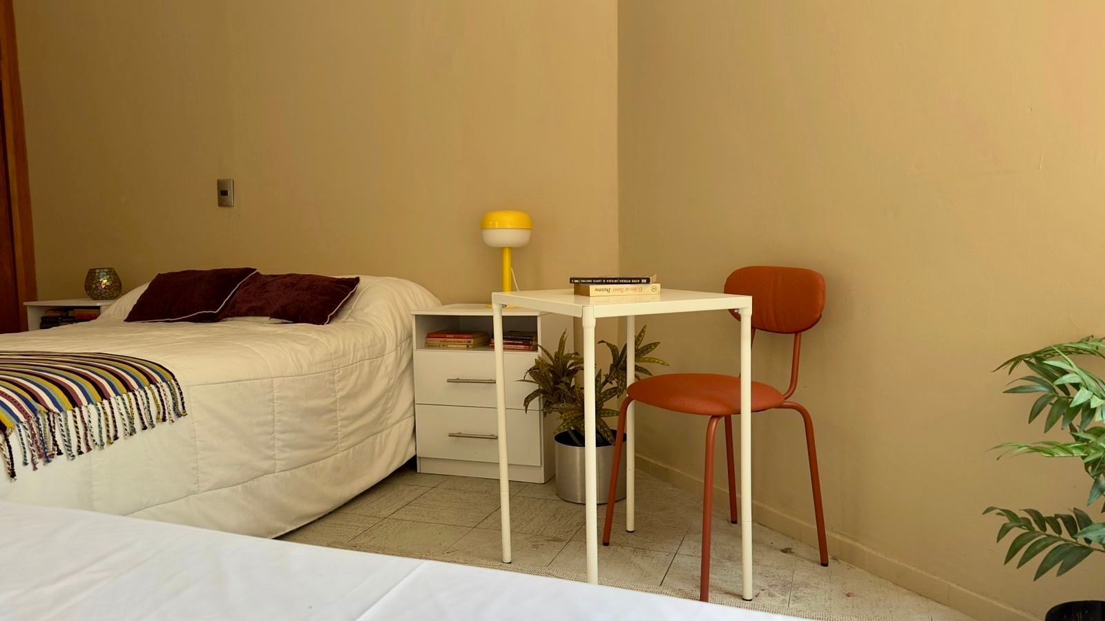 Un dormitorio con dos camas, un escritorio y una silla.