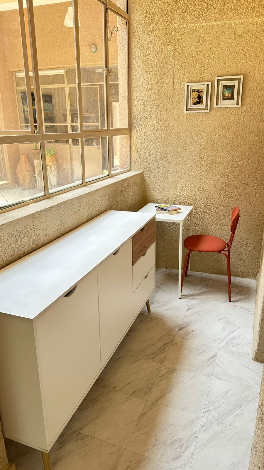 Hay una mesa y una silla en la habitación con ventana.