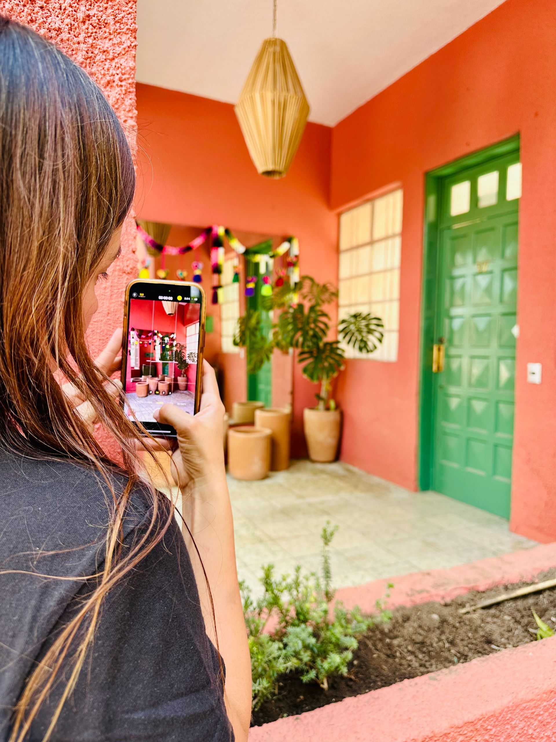 Una mujer está tomando una foto de una casa con su teléfono.
