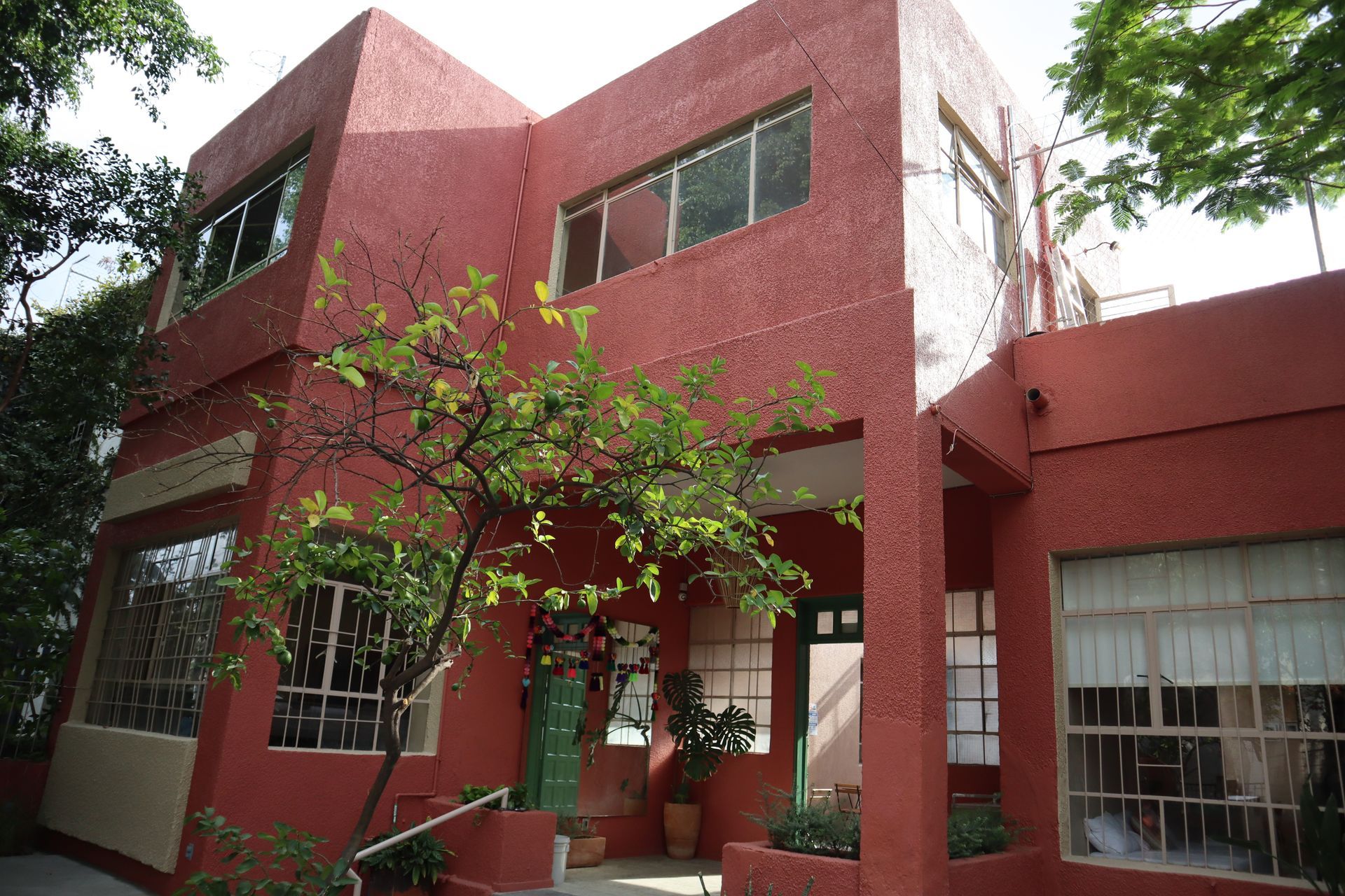 Un edificio rojo con un árbol delante.