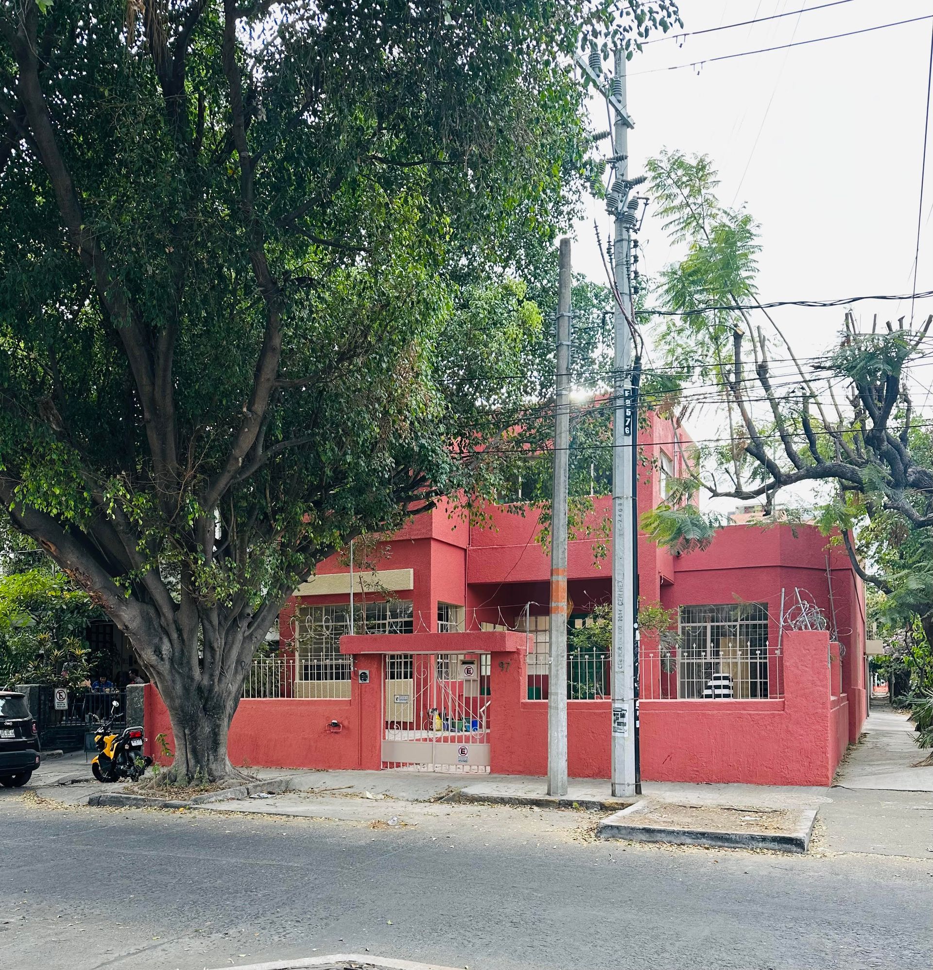 Un edificio rojo con un árbol delante.