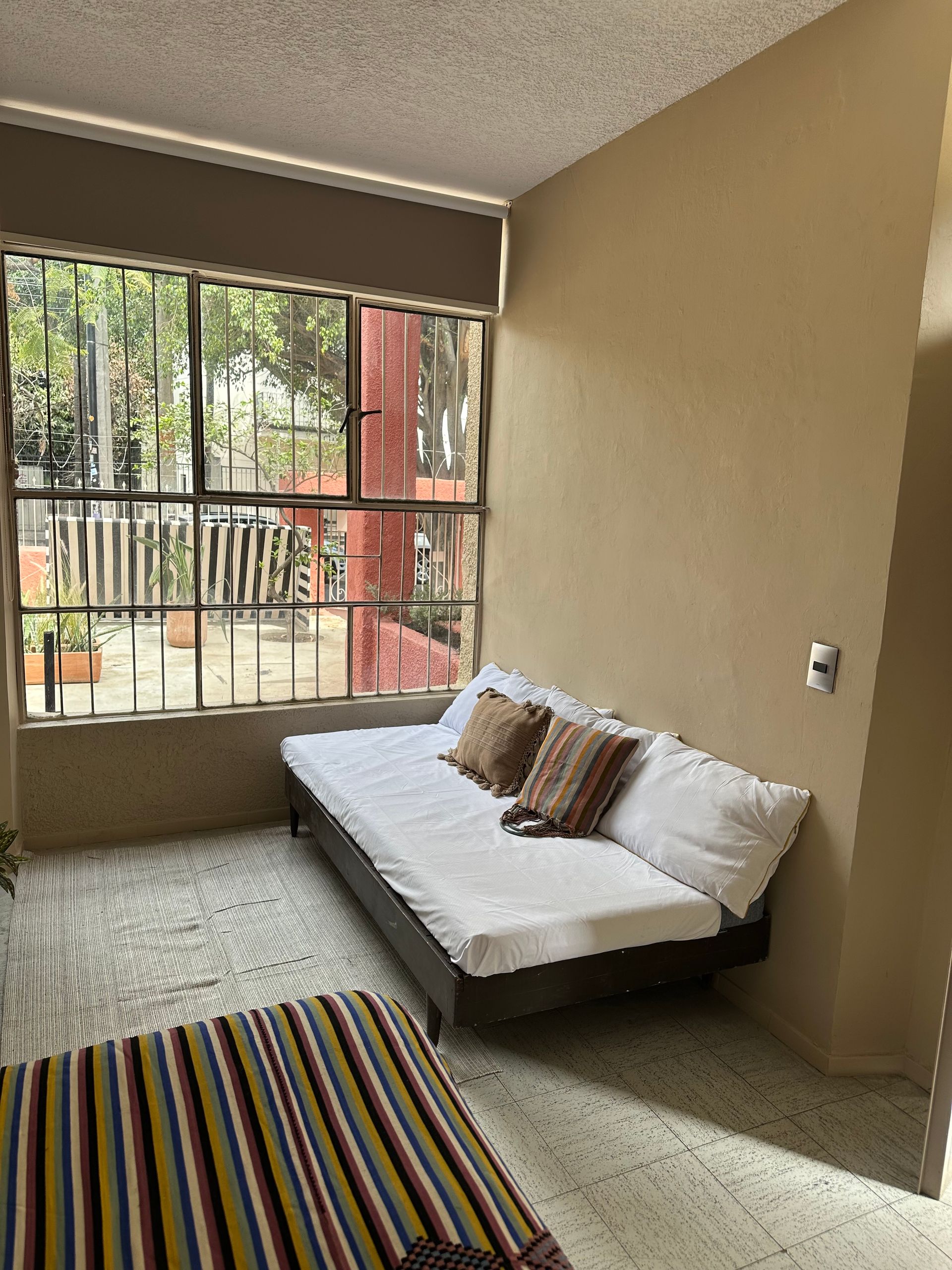 Una sala de estar con un sofá y una ventana grande.