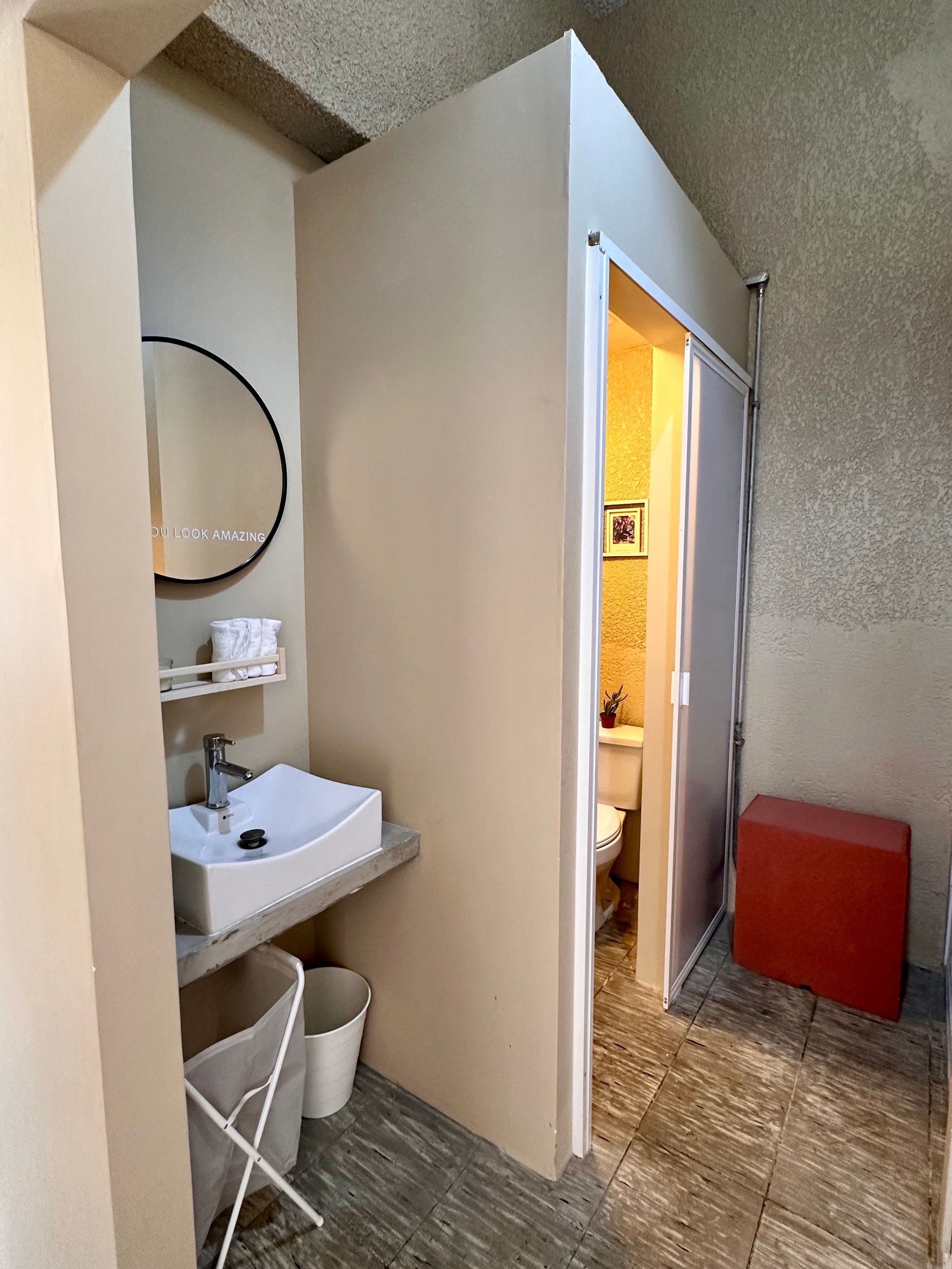 Un baño con lavabo, espejo e inodoro.