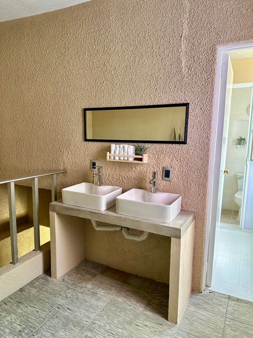 Un baño con dos lavabos y un espejo.