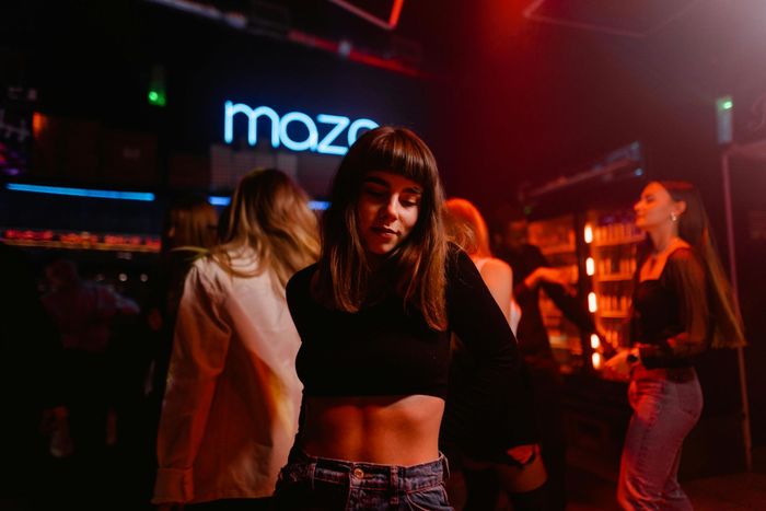 Una mujer está bailando en un club con otras personas.