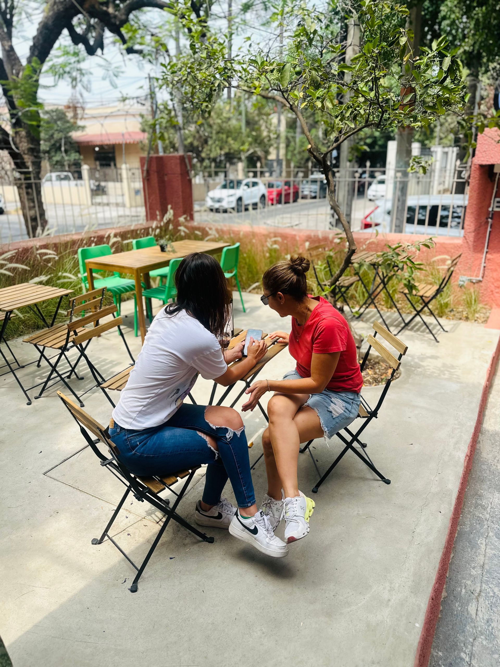 Dos mujeres están sentadas en una mesa afuera de un restaurante.