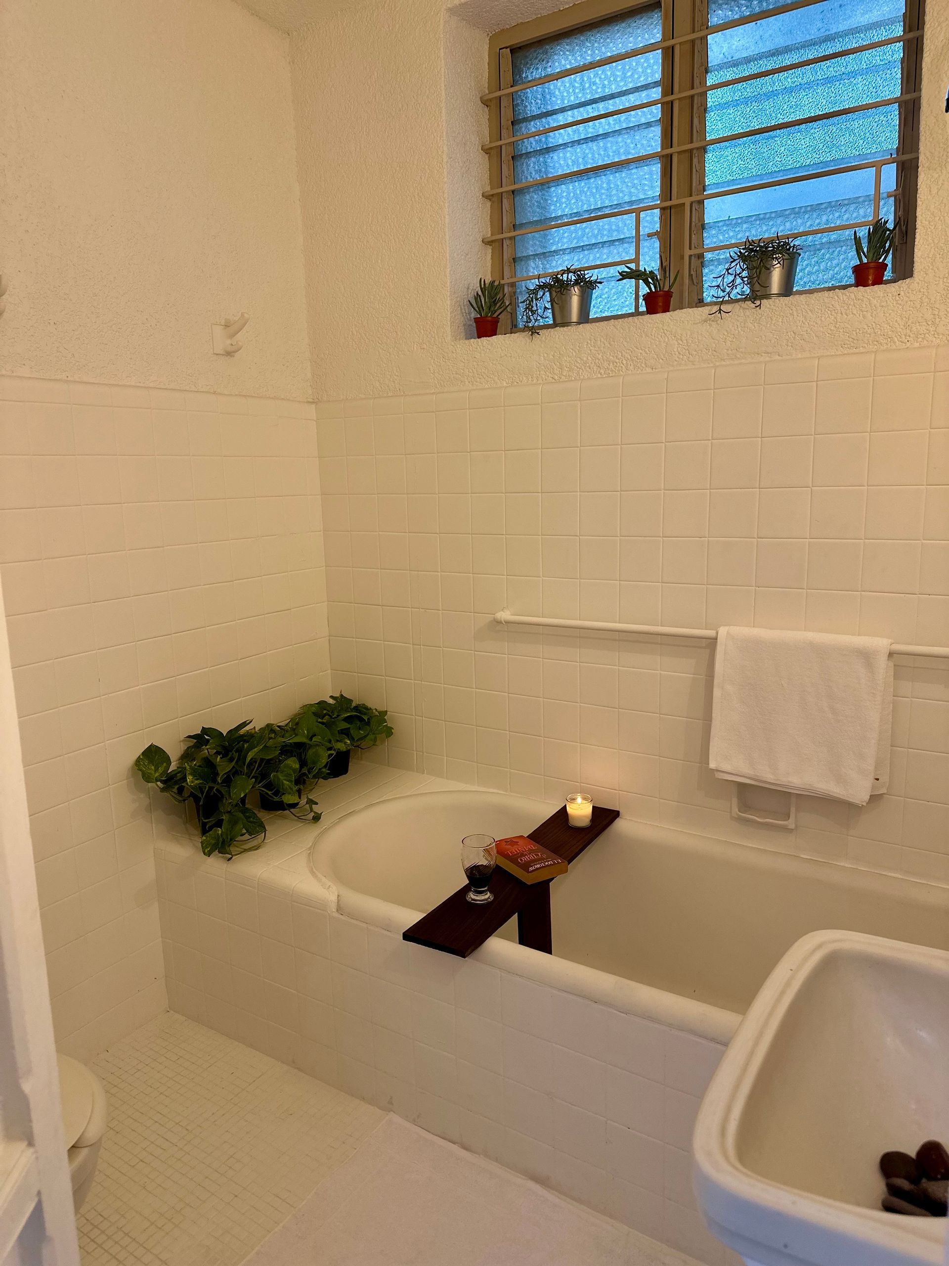 Un baño con bañera, lavabo y ventana.