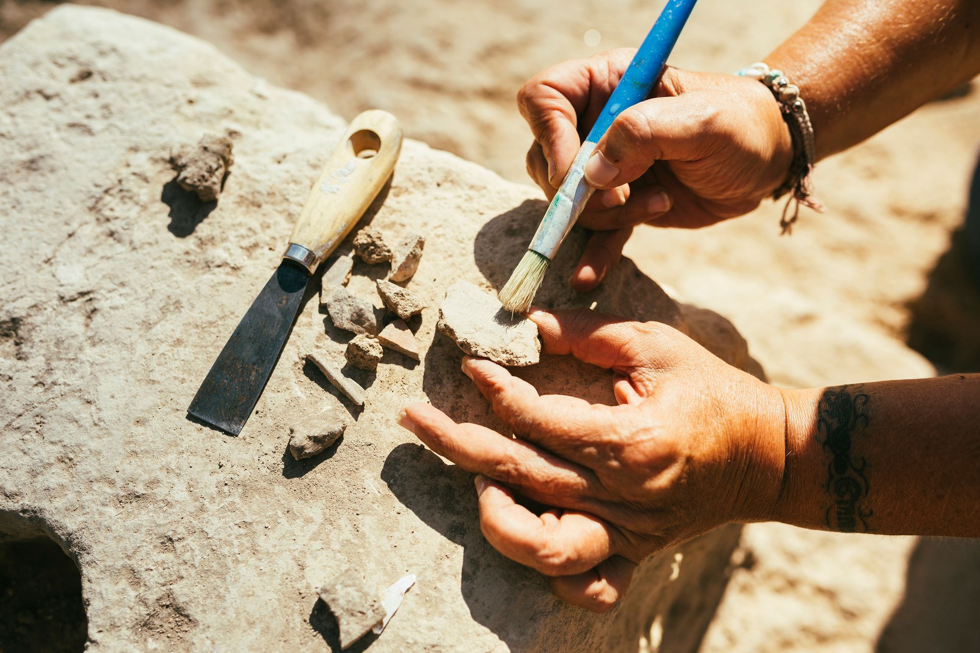 Archaeologist using a brushing a piece of ancient pottery on an archaeological excavation in NSW. Archaeologist using a brushing a piece of ancient pottery on an archaeological excavation in NSW.