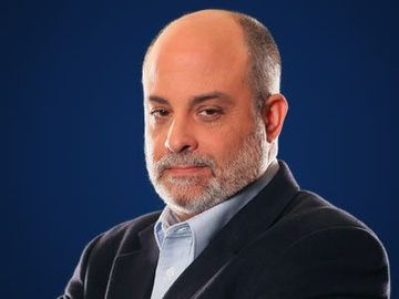 Portrait of a bald man in a dark suit and light blue shirt against a blue background