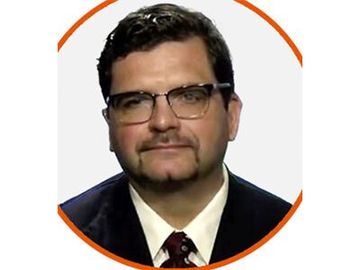Headshot of a man with glasses in a suit and tie, framed by an orange circle.